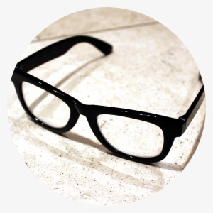 A Pair Of Thick Black Eye Glasses Sit On A White Marble - Olivers People Eyeglasses Case