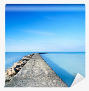 Concrete And Rocks Pier Or Jetty On Blue Ocean Water